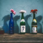 sake bottles being used a vases with flowers